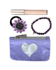 Purple pouch with a heart design, hair bun holder, lip gloss, and bracelet on a white background
