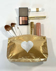 Cosmetic zipper pouch gold with silver heart containing makeup on white background