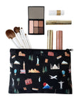 Zipper pouch in Black with world landmark print with Eiffel Tower, Big Ben, Statue of Liberty, penguin and airplane flat lay with makeup brushes and compact.