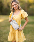 Woman holding a white and Gray Camo-pattern pouch embroidered with Gamma Phi Beta letters.