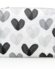 A white zippered pouch with an all-over pattern of overlapping watercolor hearts in black, gray, and white, shown on a clean white background.