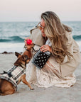 Woman with dog on beach carrying black bandana print zipper pouch.