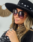 Woman in a western hat with matching silk hat band in black with heart moon star and zipper Pouch in the same pattern.