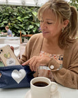 woman removing cell phone from her pouch in cafe