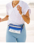 Woman running on beach wearing puffer fanny pack belt bag in harbor island beach scene print