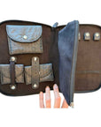 Open black travel jewelry organizer featuring storage for rings, earrings, necklaces, and small jewelry essentials.