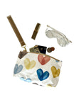 Small pouch with colorful heart designs containing glasses money lipstick on a white background