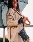 Women carrying umbrella with navy bandana print wristlet