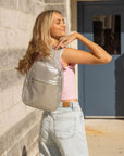 Teen walking into school wearing silver crossbody backpack