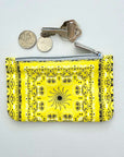 Yellow bandana pouch with change and keys on light gray background