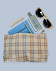 Beige and ice blue plaid cosmetic zipper pouch with sunscreen and sunglasses inside