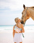 Girl with horse on beach wearing watercolor puffer crossbody fanny pack belt bag