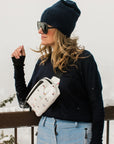 Woman in Snow Wearing Puffer Crossbody Fanny Pack Belt Bag in Dancing Skiers