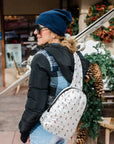 Woman in ski gear wearing skiers pattern crossbody backpack