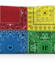 Colorful bandana-patterned clutch bag with red, yellow, blue, and green sections on a white background.