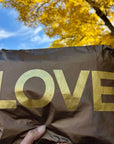 Medium zip pouch in shimmer bronze with gold love with blue sky and changing leaves in the background