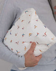 Person holding a white pouch with yoga pattern on it.