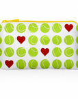 A white zippered mini pouch featuring a repeating pattern of green tennis balls and red hearts, with a yellow zipper.