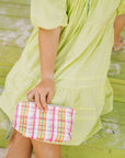 Teen with pink, yellow, orange, and green plaid zipper pouch on her lap