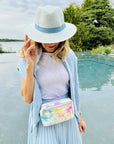 Woman by water wearing watercolor puffer crossbody fanny pack belt bag