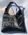 Shimmer black puffer tote bag with laptop, notpad, and pen inside