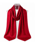 A vibrant red scarf with a repeating H signature pattern, draped on a clear mannequin torso against a solid white background.