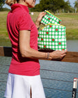 Woman holding green bags with red hearts on a golf course