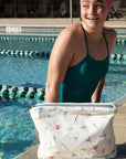 Young swimmer at edge of pool with swimmer and divers patterned zipper pouch