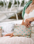 Woman with beige and sea green stars zip wristlet on her lap