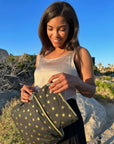 Woman using the Medium and mini pouches in black with gold stars