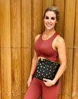 Woman carrying Black medium pouch Clutch with gold stars