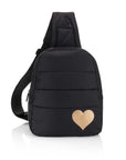 Black puffer sling backpack with a gold heart on the front and a single padded strap on white background