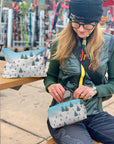 Woman Skier using zipper pouch for sunglasses with Bluebird Ski Day Pattern