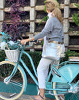 crossbody puffer purse in silver worn while riding bike