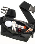 Lay flat fanny pack belt bag in black MAX with golf balls, tees, and ball markers on white background