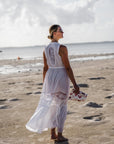 Woman on beach wearing white dress and medium zipper pouch in "language of love" pink heart print