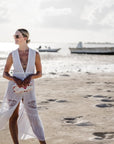 Women on beach wearing white dress and sunglasses holding medium zipper pouch in "Language of Love" pink heart print
