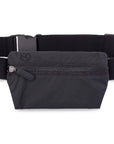 A black lay flat fanny pack belt bag with an adjustable elastic belt a front zipper pocket and inside zipper pocket on white background