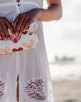 Woman on beach holding medium zipper pouch in "language of love" pink heart print
