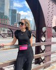 Woman standing on Chicago bridge wearing hot pink fanny pack