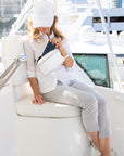 Woman sitting on boat wearing shimmer white crossbody puffer fanny pack