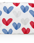 A medium zipper pouch with a printed pattern of red, white, and blue hearts on a white background.