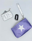 Purple wristlet with silver star, card pouch, and car keys on white background
