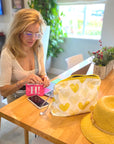 Woman sitting at table with yellow heart pouch