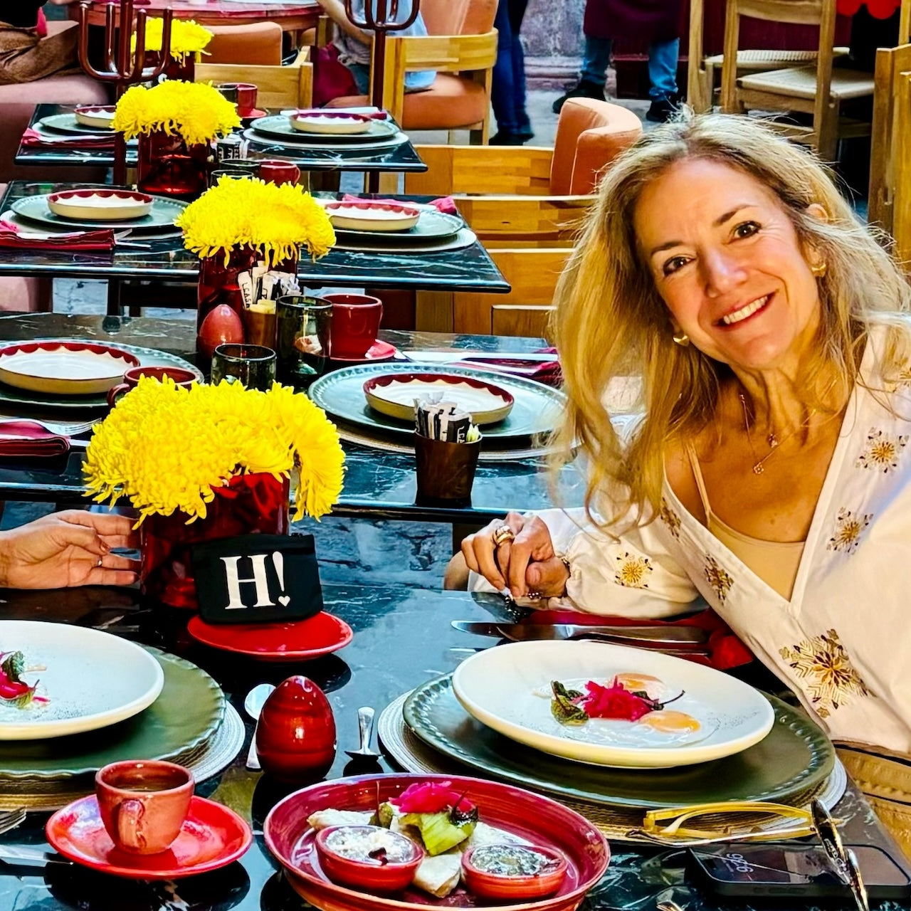 Woman smiling at restaurant with black card pouch on the table