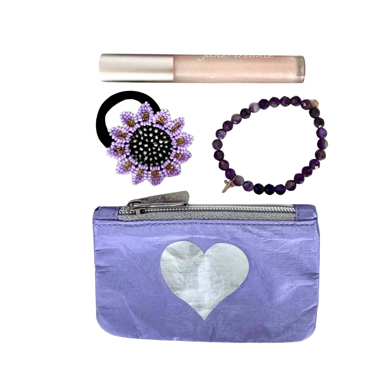Purple pouch with a heart design, hair bun holder, lip gloss, and bracelet on a white background