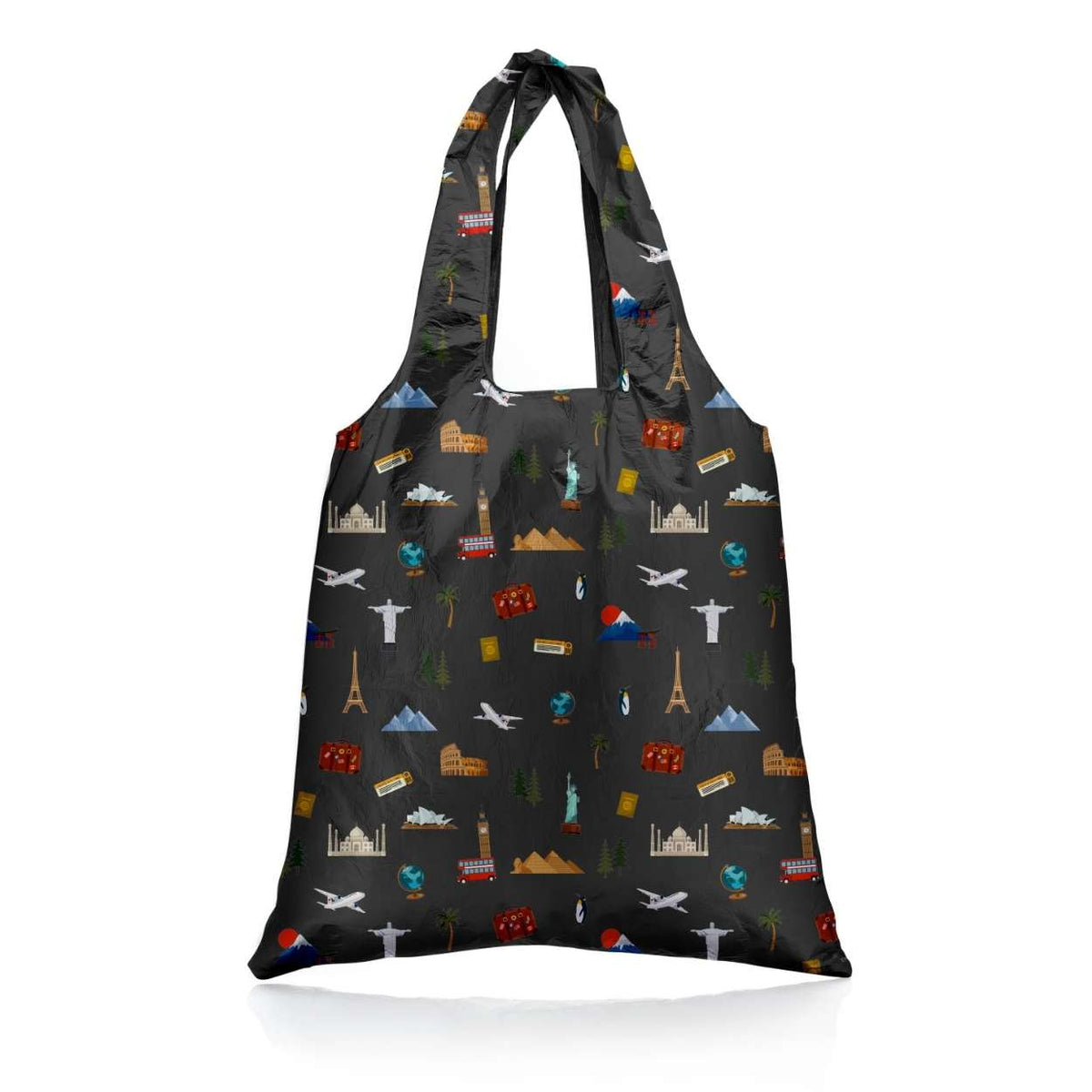 A reusable folding tote bag with a black background and an all-over travel-themed print featuring landmarks from the seven continents along with airplanes, a globe, mountains, a passport and a luggage in small multicolor icons, shown on a clean white background.