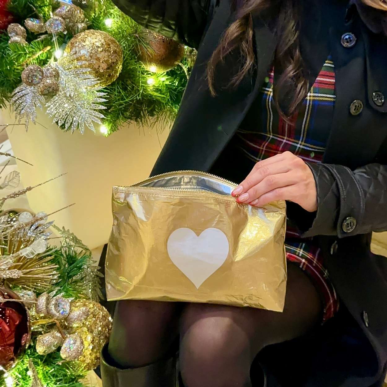 cosmetic zipper pouch clutch on women's lap with holiday lights