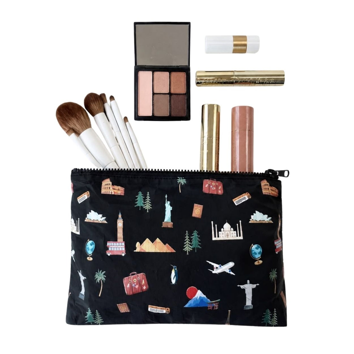 Zipper pouch in Black with world landmark print with Eiffel Tower, Big Ben, Statue of Liberty, penguin and airplane flat lay with makeup brushes and compact.