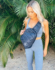 Woman in workout set with crossbody backpack in shimmer navy with tonal star on palm tree background